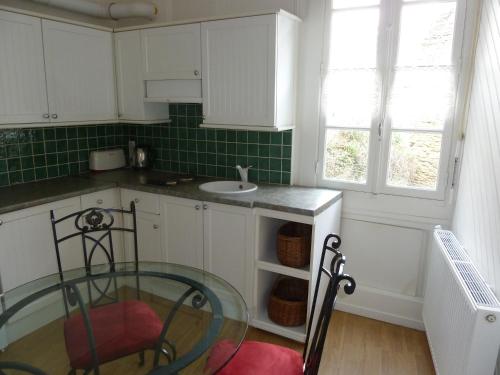 - une cuisine avec une table en verre et un évier dans l'établissement Le Point d'Orgue, à Rennes