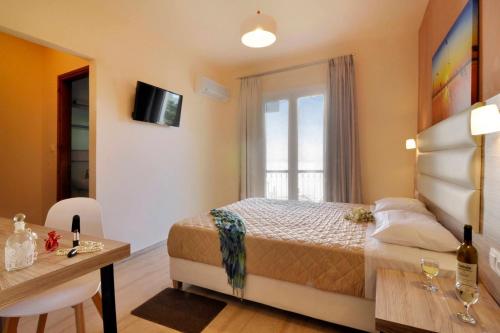 a bedroom with a bed and a desk and a window at Hotel Orpheus in Gouvia