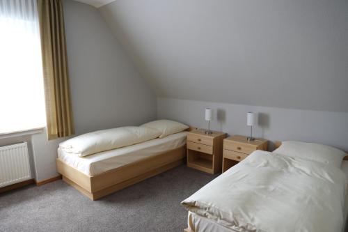 1 Schlafzimmer mit 2 Betten und 2 Nachttischen in der Unterkunft Ferienhaus zur Sonne in Olsberg