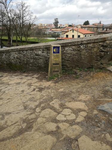 a stone wall with a sign in front of it at Casa Carlán in Melide