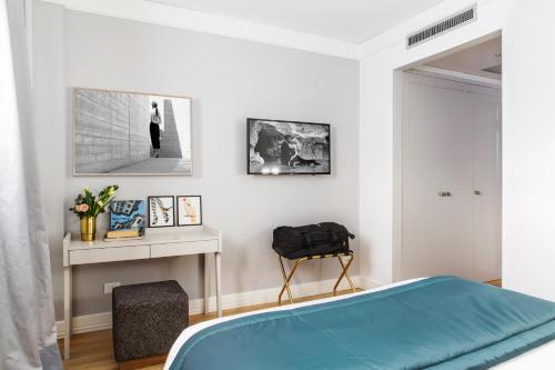 a bedroom with a blue bed and a table at Favilla Hotel di Charme in Rome