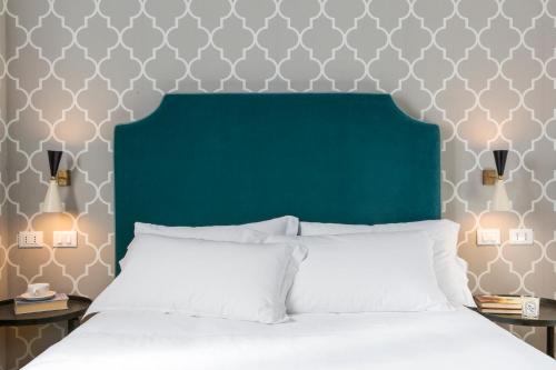 a bedroom with a bed with a green headboard at Favilla Hotel di Charme in Rome