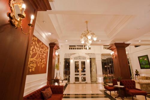 a lobby with a chandelier and chairs in a building at Dhavara Boutique Hotel in Vientiane