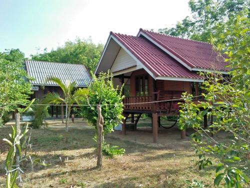a house with a red roof in a forest at Bang Hon Homestay in Ko Yao Noi