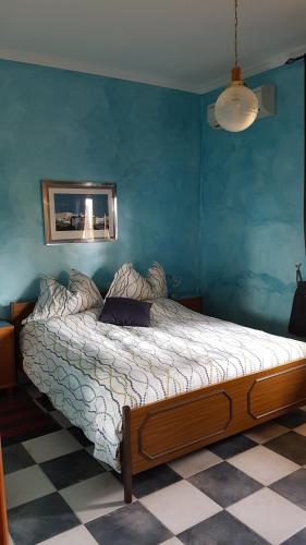 sypialnia z łóżkiem w niebieskiej ścianie w obiekcie Guest house Il Nido w mieście Velletri