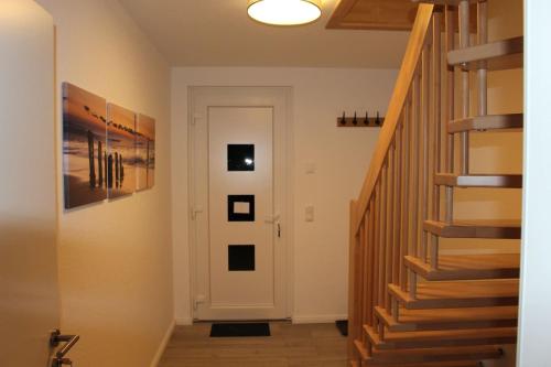a hallway with a white door and a staircase at Schöne 54qm Fewo nahe Rostock und Warnemünde in Lambrechtshagen