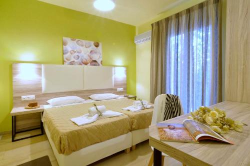 a hotel room with two beds and a table at Hotel Orpheus in Gouvia