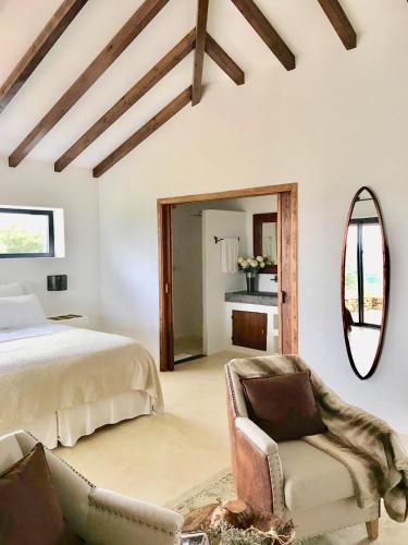 a bedroom with a bed and a chair and a mirror at Sharish - Monte Das Estevas in Estremoz