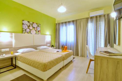a hotel room with a bed and a desk and a room at Hotel Orpheus in Gouvia