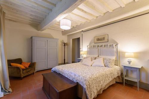 una camera da letto con un letto e una sedia di Casa Arancio - Fattoria la Speranza, Case Toscane ad Anghiari