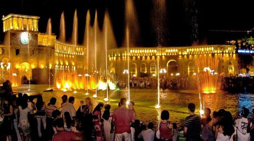 a group of people standing in front of a building with fountain at Hotel Victoria in Yerevan