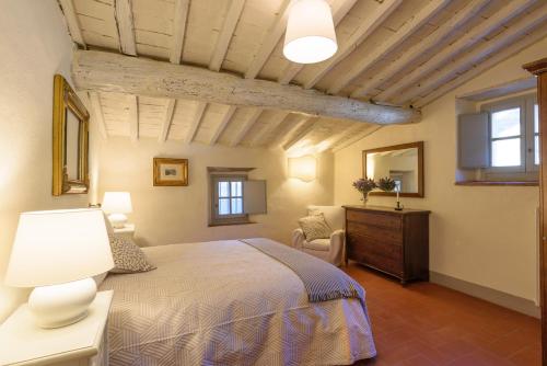 um quarto com uma cama, uma cómoda e janelas em Fattoria la Speranza, Case Toscane, Casa Vaniglia em Anghiari