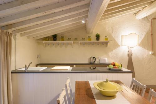 uma cozinha com uma mesa com uma tigela amarela em Fattoria la Speranza, Case Toscane, Casa Vaniglia em Anghiari