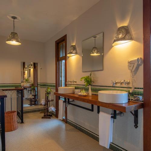 a bathroom with two sinks and a large mirror at Quinta dos Pinhais Pouso e Charme in Santo Antônio do Pinhal