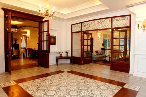 a large room with a hallway with doors and a rug at Dhavara Boutique Hotel in Vientiane