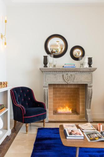 a living room with a fireplace and a blue rug at Favilla Hotel di Charme in Rome