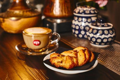 a table with a plate of pastries and a cup of coffee at IL VIAGGIATORE VIA INDIPENDENZA B&B in Gaeta