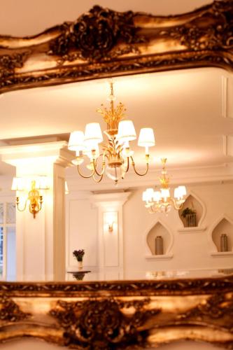 a mirror reflecting a room with a chandelier at Dhavara Boutique Hotel in Vientiane