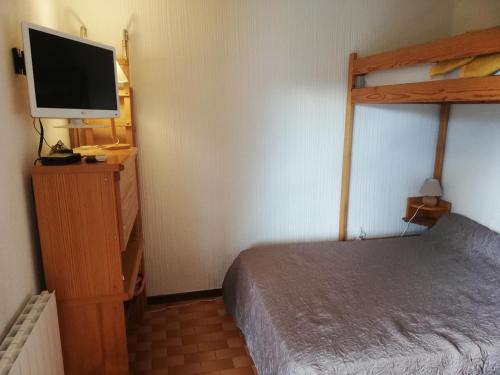 - une chambre avec un lit et une télévision à écran plat dans l'établissement Résidence Le Parc, à Font-Romeu-Odeillo-Via