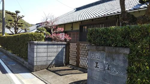 a house with a fence and some bushes at 玉の浦sea in Nachikatsuura