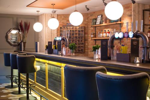 a bar at a restaurant with blue chairs at Mercure Oxford Eastgate Hotel in Oxford