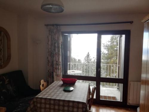 Pokój ze stołem i dużym oknem w obiekcie Résidence Le Parc w mieście Font-Romeu-Odeillo-Via