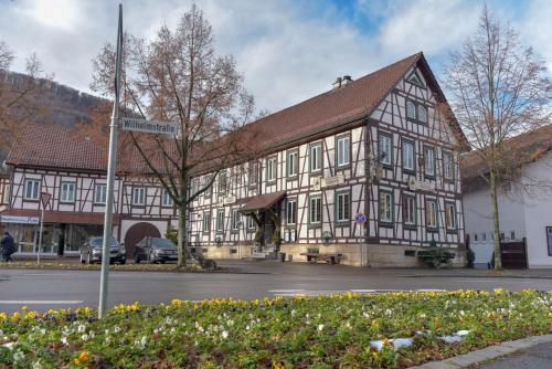a large wooden building with a street sign in front of it at Hotel Ristorante Rostica in Bad Urach
