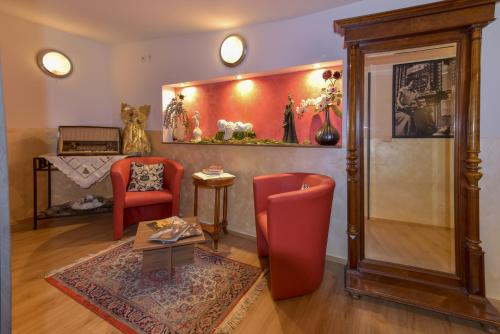 a living room with two red chairs and a table at Hotel Ristorante Rostica in Bad Urach