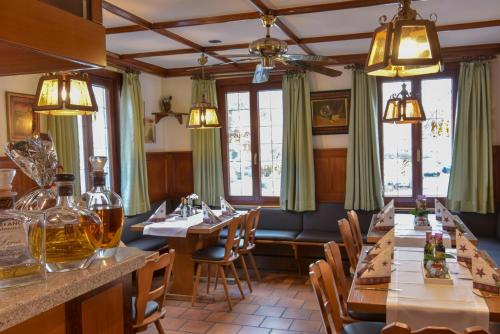 a restaurant with long tables and chairs and windows at Hotel Ristorante Rostica in Bad Urach