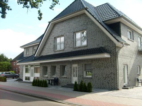 ein Backsteinhaus mit einem Gameradach in der Unterkunft Comfort Apartments SNF zertifiziert in Gronau