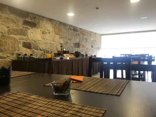 a dining room with a table and a stone wall at Encosta do Sossego in Cabeceiras de Basto