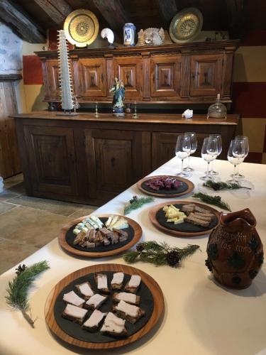 a table with three plates of food and wine glasses at Confrérie du Moyen Âge in Verrayes