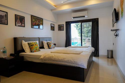 a bedroom with a large bed with a window at Athi Resorts in Bogmolo