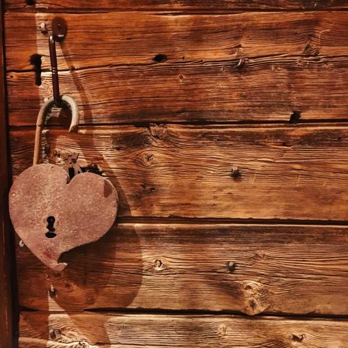 a heart shaped lock on a wooden door at Confrérie du Moyen Âge in Verrayes