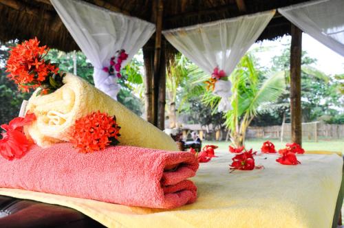 a towel sitting on top of a table with flowers at Ankobra Beach Resort in Axim