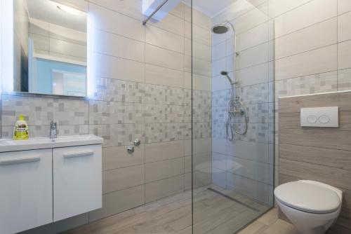 a bathroom with a shower and a toilet and a sink at Villa Serenity in Hvar