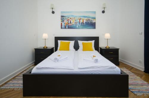 a bedroom with a large bed with yellow pillows at Belgrade CITY CENTER Apartments in Belgrade