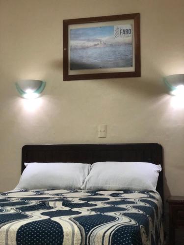 Una cama o camas en una habitación de Hotel El Faro Malecon