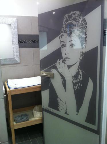 ein Badezimmer mit einem Poster einer Frau in der Unterkunft Hotel Donegal in Cesenatico
