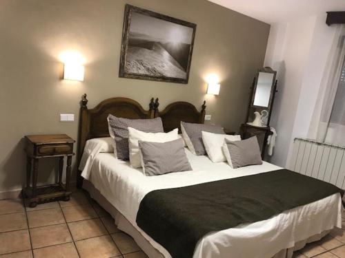 - une chambre avec un grand lit et des oreillers dans l'établissement Hotel Patri, à Huéscar