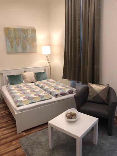 ブダペストにあるRoxana apartmentsのベッド1台、椅子、テーブルが備わる客室です。