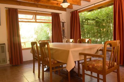 comedor con mesa, sillas y ventana en Ventana a los Cerros en Villa La Angostura