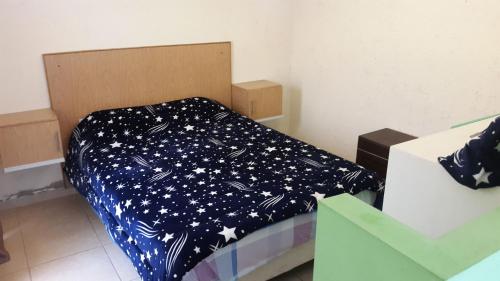 a bed with a blue comforter with stars on it at Kaizen in Mendoza
