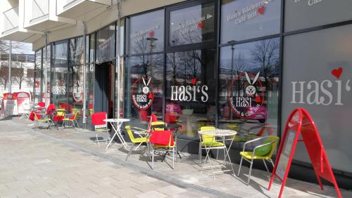 a store with tables and chairs in front of a window at Myroom Business Apartment Nähe Messe München in Munich