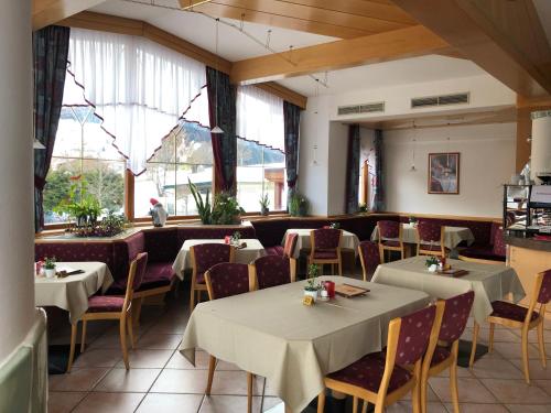 a dining room with tables and chairs and windows at Der Burgfellnerhof - Adults Only in Schladming