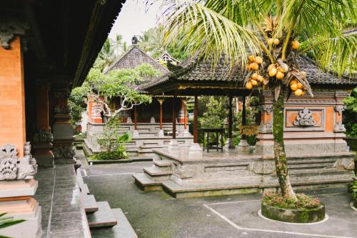 un bâtiment avec un palmier en face dans l'établissement Gunung Kawi House, à Tegalalang