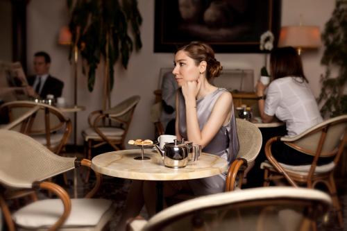 a woman sitting at a table in a cafe at Hotel Best in Ankara