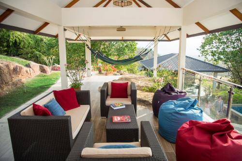 a porch with couches and pillows on it at Ranis Lodge in Kampung Padang Masirat