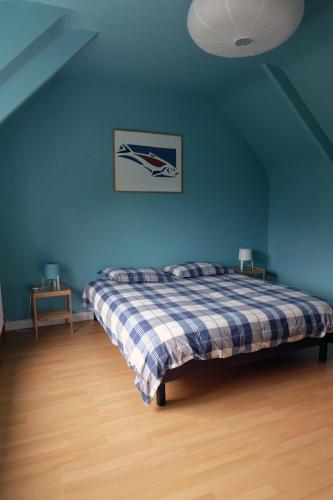 - une chambre bleue avec un lit et une couverture tressée dans l'établissement 31 Chemin de la Croix aux Outils, à Paimpol