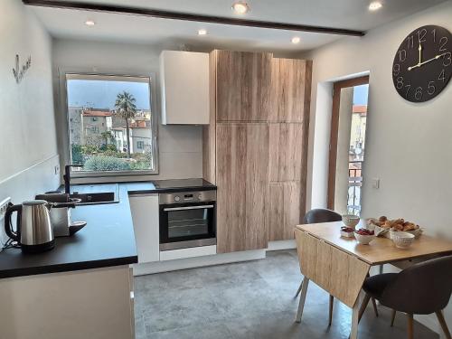 Una cocina con una mesa y un reloj en la pared. en Vieil Antibes Charming Guillaumont, en Antibes